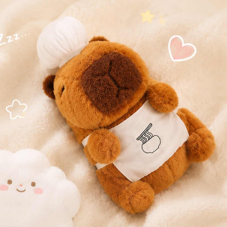 Peluche capybara chef kawaii vue de face, expression calme et mignonne, toque blanche et tablier 🦫
