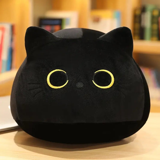 une peluche en forme de chat noir toute ronde et toute câline. Elle a des grands yeux expressifs. Style minimaliste et adorable