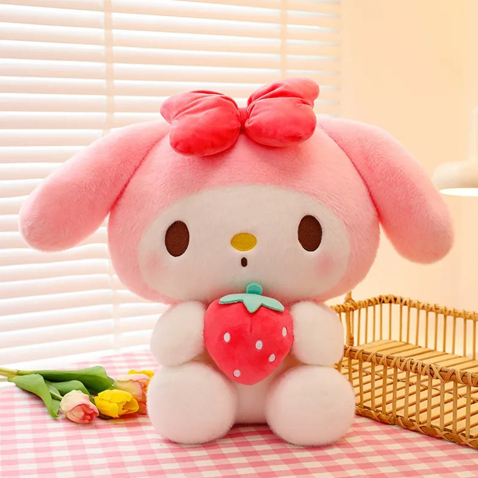 une adorable peluche My Melody toute mignonne et super douce qui tient une fraise dans ses mains.