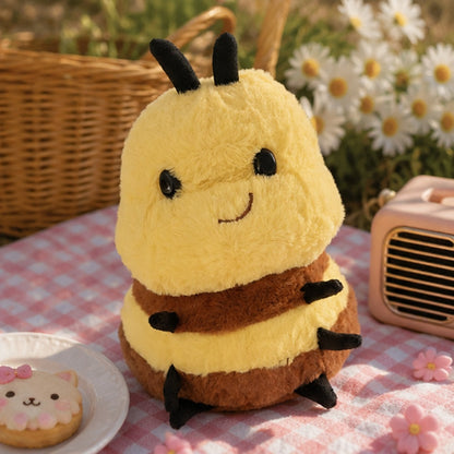 Peluche abeille kawaii dans un décor pique-nique printanier, avec nappe vichy rose, marguerites, panier en osier et accessoires pastel.