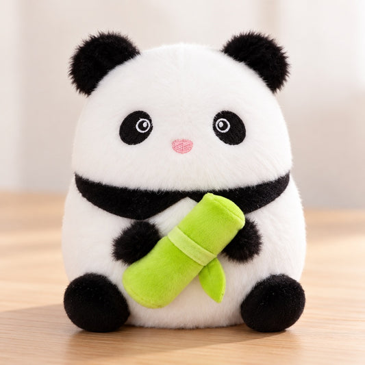 Peluche panda kawaii noire et blanche tenant un bambou vert dans ses pattes, ultra douce et adorable, présentée sur un fond clair et épuré.