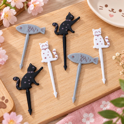 Lot de 6 pics décoratifs kawaii pour bento et apéritif, avec chats noirs, chats blancs et poissons gris, présentés dans un décor japonais fleuri.