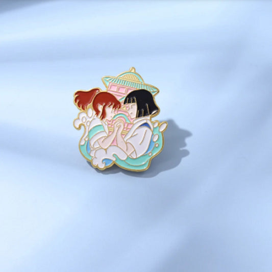 un superbe pin's représentant Chihiroet Kohaku qui se tiennent par la main et re gardent. L'ensemble représente leur lien unique et profond.