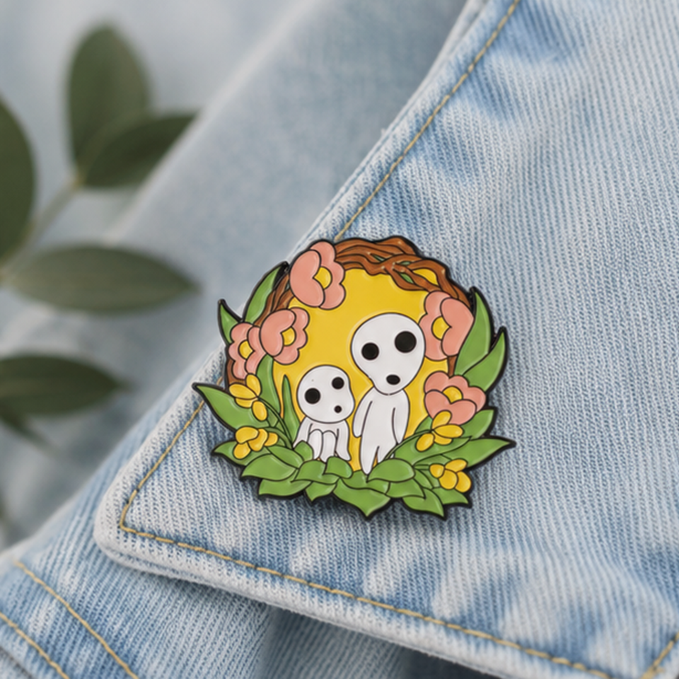 un joli pin's représentant des kodamas, petits êtres mystérieux de la fôret. ils sont dans un décor fleuri et nature