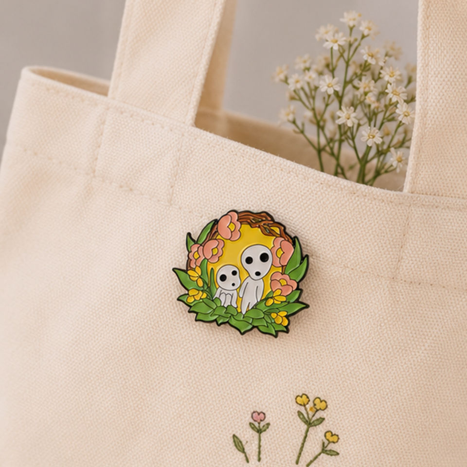 un joli pin's représentant des kodamas, petits êtres mystérieux de la fôret. ils sont dans un décor fleuri et nature