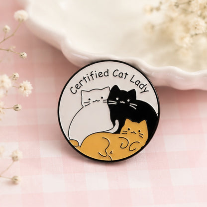 Pin's la dame aux chats kawaii porté sur une veste, accessoire humour et douceur féline ✨