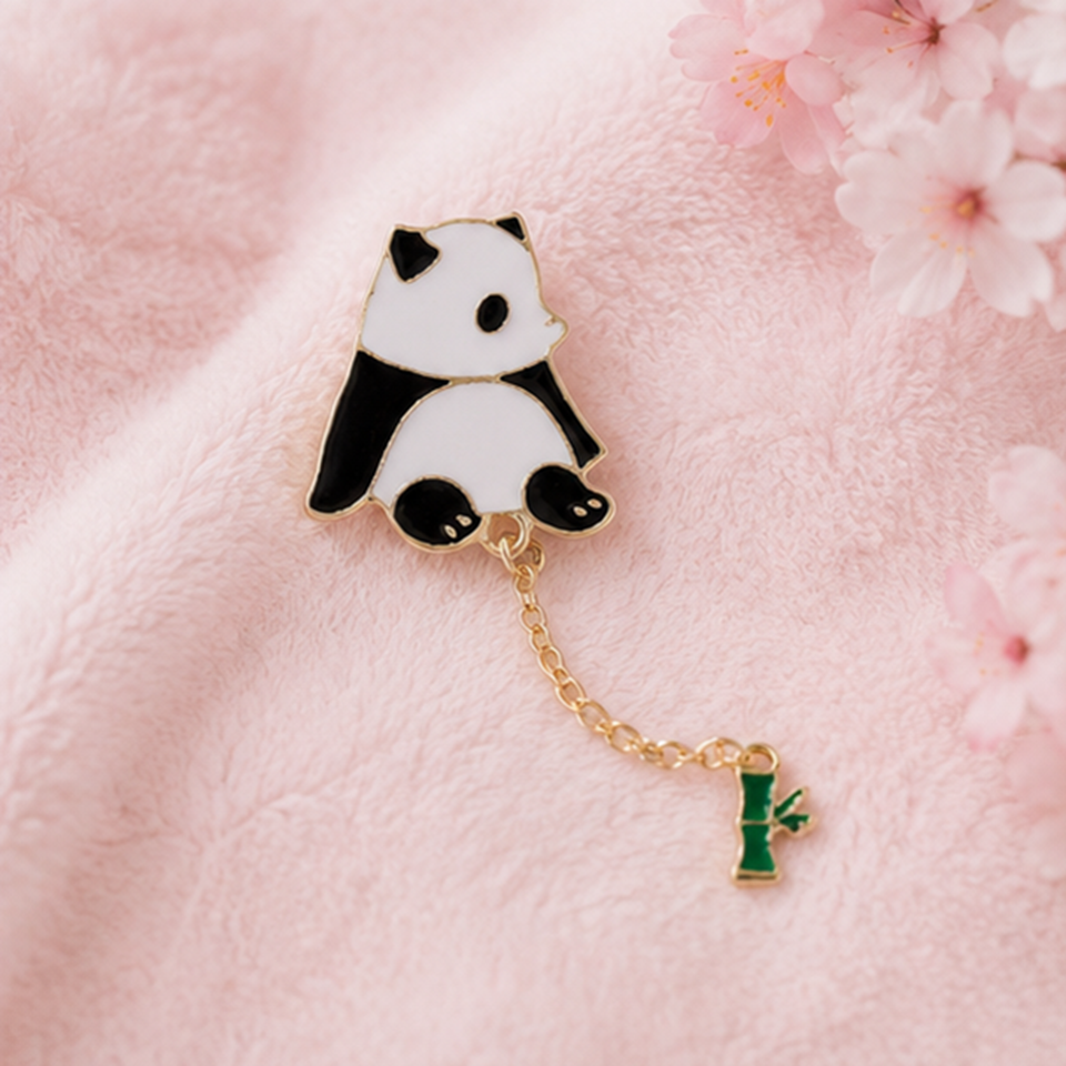 un pin's en forme d'un panda très mignon au bout, il y a une chainette avec un petit bambou