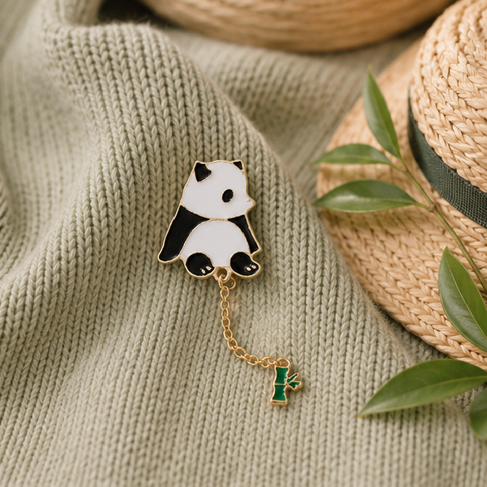 un pin's en forme d'un panda très mignon au bout, il y a une chainette avec un petit bambou