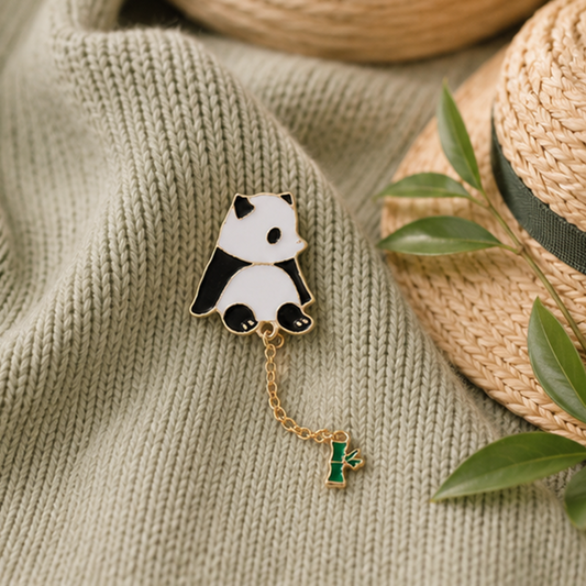 un pin's en forme d'un panda très mignon au bout, il y a une chainette avec un petit bambou