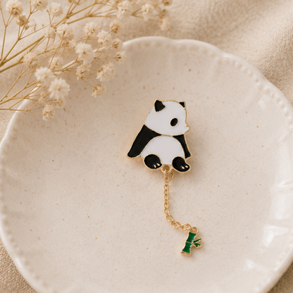un pin's en forme d'un panda très mignon au bout, il y a une chainette avec un petit bambou