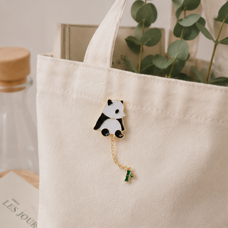 un pin's en forme d'un panda très mignon au bout, il y a une chainette avec un petit bambou