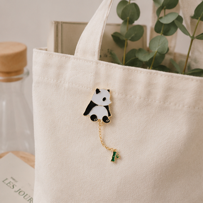 un pin's en forme d'un panda très mignon au bout, il y a une chainette avec un petit bambou