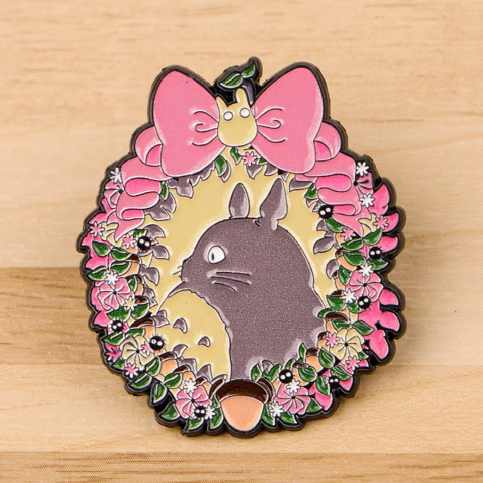un pin's représentant Totoro dans une couronne de fleurs 