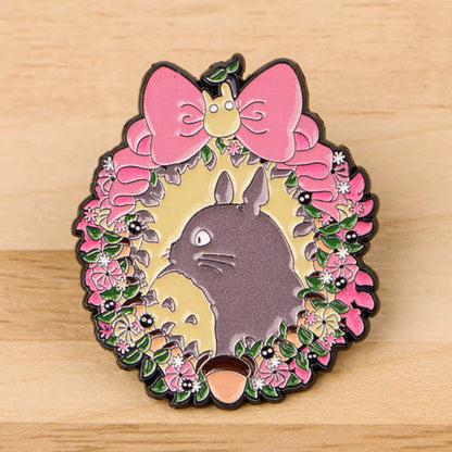un pin's représentant Totoro dans une couronne de fleurs 