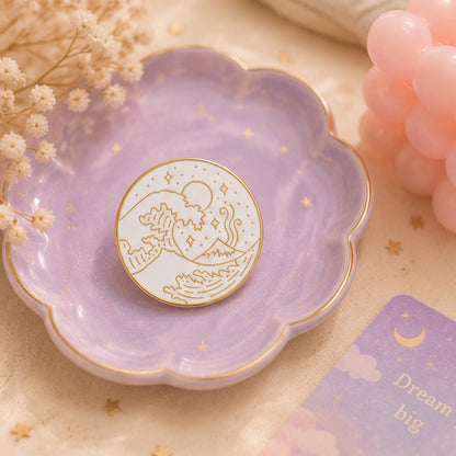 Pin’s vague japonaise minimaliste blanc et doré présenté dans une jolie coupelle violette pastel ✨ Badge élégant inspiré de la Grande Vague de Kanagawa avec détails raffinés représentant les vagues, le mont Fuji et un ciel étoilé. Ambiance douce, poétique et féerique parfaite pour une collection kawaii ou un accessoire japonais chic.