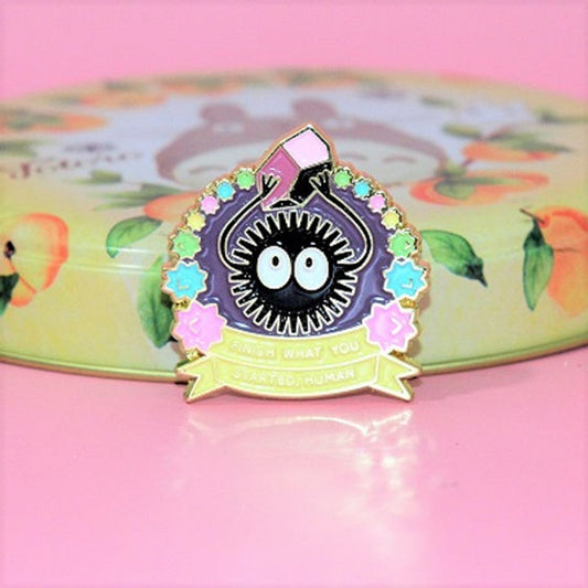 un pin's représentant une noiraude qui soulève un morceau de charbon trop lourd pour elle. Symbole de force, de confiance en soi.