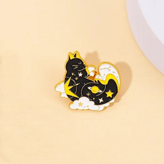 un pin's en forme de chat noir dont la fourrure ressemble à une galaxie remplie d'étoiles. Il dort paisiblement dans des nuages blancs.
