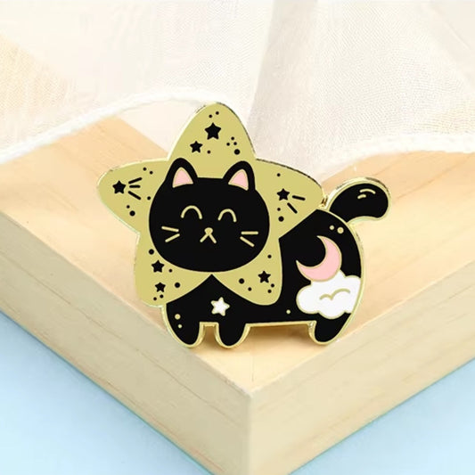 un pin's doré en forme d'un chat noir bien dodu et tout mignon dans la fourrure est ornée d'un croissant de lune et d'un nuage. Il a la tête dans une grande étoile dorée.