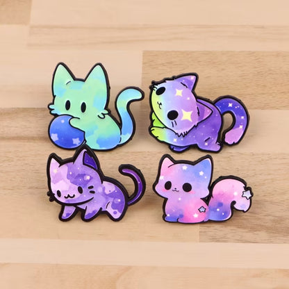 des jolis pin's en forme de chat et aux couleurs de la galaxie : vert, rose bleu, violet. Ils transcendent le caractère mystérieux et imprévu du chat.