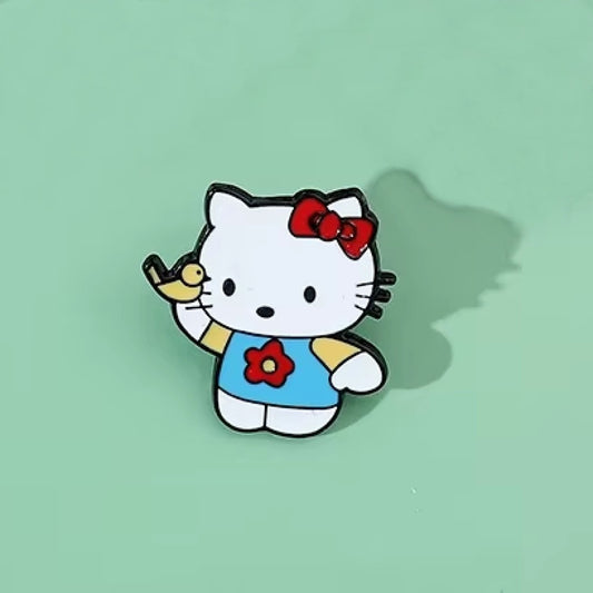 un pin's en forme de l'adorable Hello Kitty qui joue avec un petit oiseau jaune. 