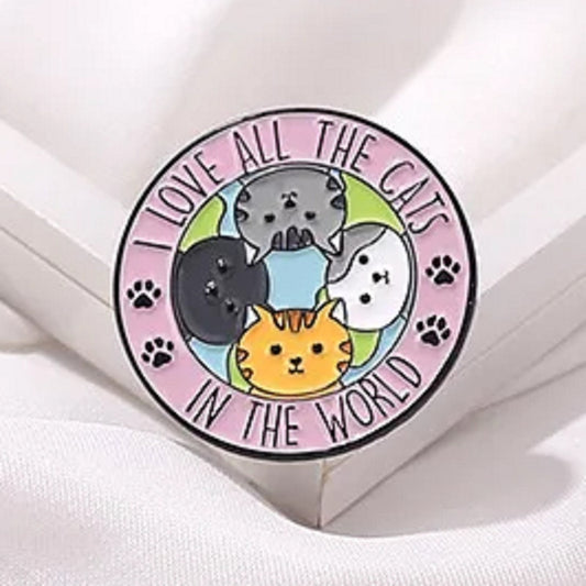 un pin's en forme de badge représentant des chats de toutes les couleurs avec l'inscription I love all the cats in the world. C'est un signe d'amour envers tous les félins du monde.