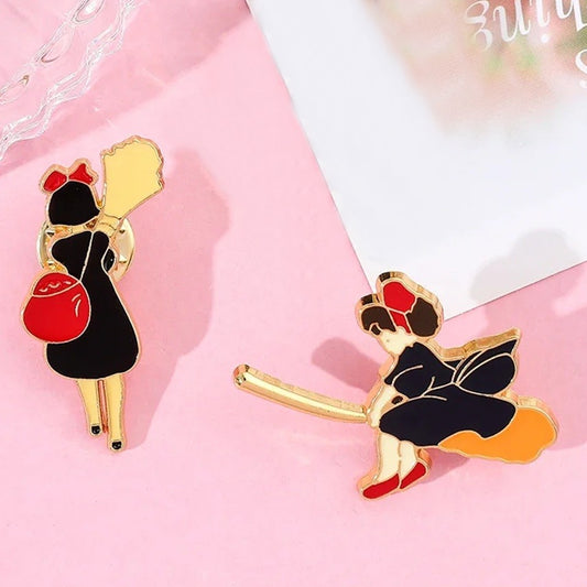des pin's représentant la jeune Kiki la petite sorcière. Elle s'envole sur son balai ou elle le porte. On reconnait son noeud rouge dans ses cheveux.