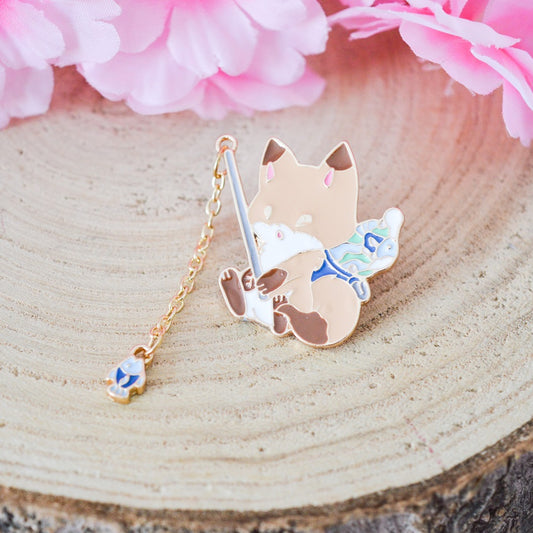 un pin's en forme de renard qui est en train de pêcher. Il a une canne à pêche composée d'une chainette. Au bout se trouve un poisson !