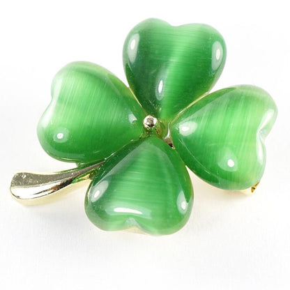 un pin's doré en forme de trèfle vert à 4 feuilles. Les feuilles sont en résine brillantes. Symbole de chance. Look élégant et mignon à la fois.