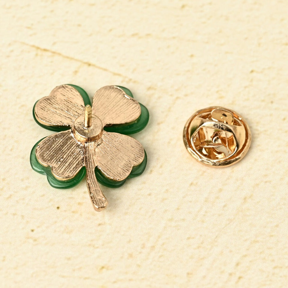 un pin's doré en forme de trèfle vert à 4 feuilles. Les feuilles sont en résine brillantes. Symbole de chance. Look élégant et mignon à la fois.