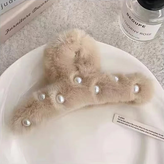 une pince à cheveux beige en peluche toute douce et ornée de perles blanches pour un effet élégant et chic.