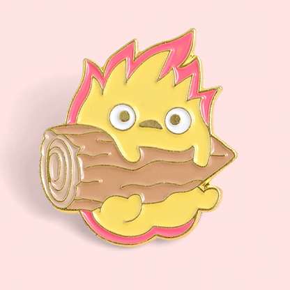 un adorable pin's représentant Calcifer le personnage du château ambulant tenant une buche de bois sur un fond rose. Idéal à collectionner.