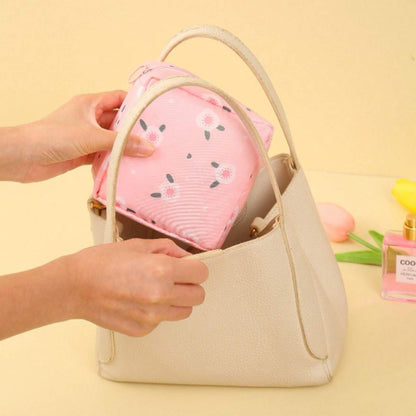 une adorable  petite pochette de rangement pour protections hygiéniques au motif de fleurs. Format pratique à glisser dans son sac.