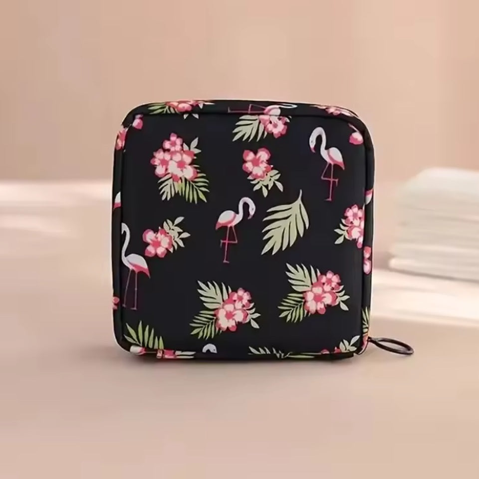 une pochette de rangement zippée au motif de flamants roses et de fleurs exotiques pour transporter en toute discrétion protections hygiéniques. Peut également servir pour y ranger maquillage et petits accessoires.