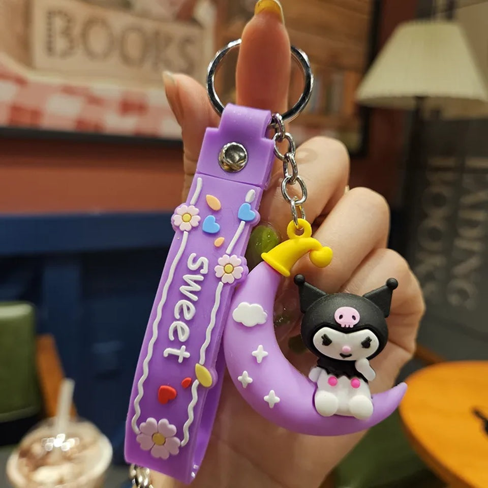 un porte-clé représentant Kuromi assise sur une lune violette. Ensemble poétique et mignon.