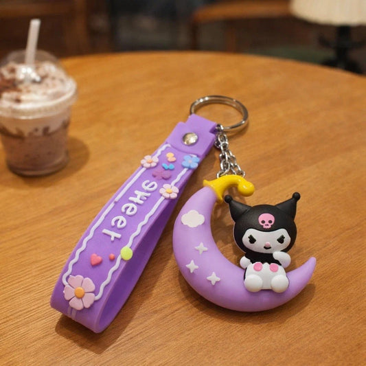 un porte-clé représentant Kuromi assise sur une lune violette. Ensemble poétique et mignon.