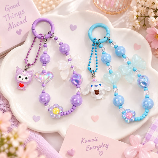 Porte-clés kawaii en perles violettes et bleues avec breloques Kuromi et Cinnamoroll, décorés de nœuds, cœurs et fleurs colorées dans une ambiance pastel.
