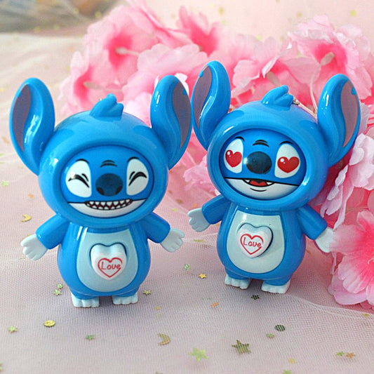 un porte-clés en forme de Stitch de Lilo et Stitch. Il a un petit coeur sur le ventre qui permet de changer son expression de visage. Tant espiègle, tnatot amoureux, il est trop adorable !