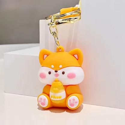 un adorable porte-clé en forme de shiba inu jaune qui tient une boisson. Il est trop mignon ! Un accessoire à accrocher à votre sac et à vos clés.