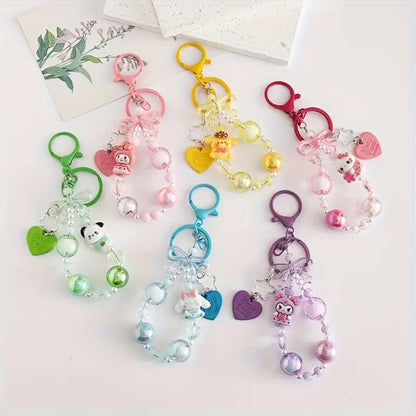 des porte-clés hyper kawaii aux couleurs des personnages Sanrio : Kuromi, Cinnamoroll, Pompompurin, My Melody, Hello Kitty et Pochacco. Cahque porte-clé est composé d'une breloque du personnage, de perles colorées en fonction du personnage et de breloques en forme de noeud et coeur hyper mignons.