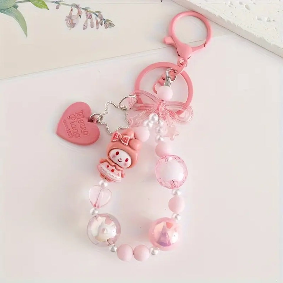 des porte-clés hyper kawaii aux couleurs des personnages Sanrio : Kuromi, Cinnamoroll, Pompompurin, My Melody, Hello Kitty et Pochacco. Cahque porte-clé est composé d'une breloque du personnage, de perles colorées en fonction du personnage et de breloques en forme de noeud et coeur hyper mignons.