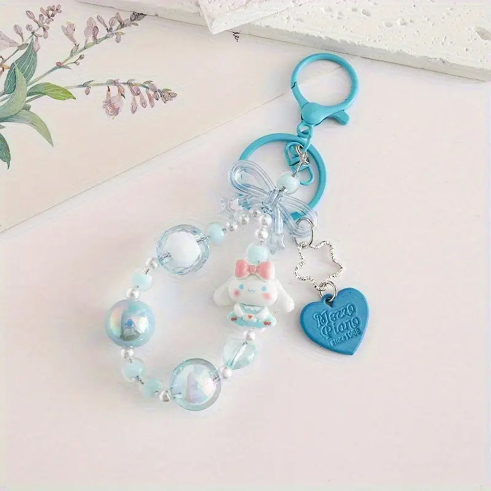 des porte-clés hyper kawaii aux couleurs des personnages Sanrio : Kuromi, Cinnamoroll, Pompompurin, My Melody, Hello Kitty et Pochacco. Cahque porte-clé est composé d'une breloque du personnage, de perles colorées en fonction du personnage et de breloques en forme de noeud et coeur hyper mignons.