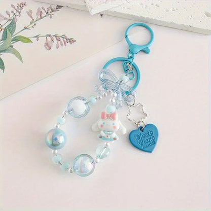 des porte-clés hyper kawaii aux couleurs des personnages Sanrio : Kuromi, Cinnamoroll, Pompompurin, My Melody, Hello Kitty et Pochacco. Cahque porte-clé est composé d'une breloque du personnage, de perles colorées en fonction du personnage et de breloques en forme de noeud et coeur hyper mignons.