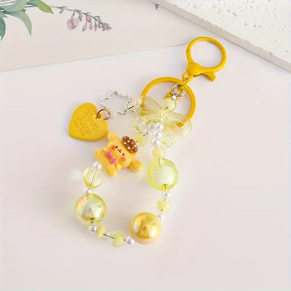 des porte-clés hyper kawaii aux couleurs des personnages Sanrio : Kuromi, Cinnamoroll, Pompompurin, My Melody, Hello Kitty et Pochacco. Cahque porte-clé est composé d'une breloque du personnage, de perles colorées en fonction du personnage et de breloques en forme de noeud et coeur hyper mignons.