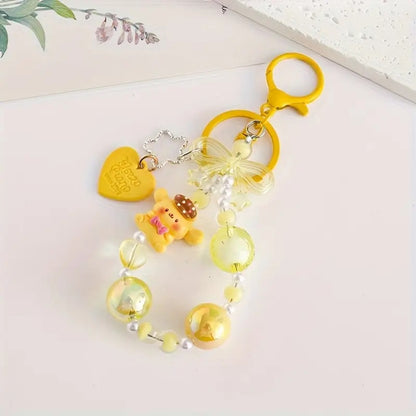 des porte-clés hyper kawaii aux couleurs des personnages Sanrio : Kuromi, Cinnamoroll, Pompompurin, My Melody, Hello Kitty et Pochacco. Cahque porte-clé est composé d'une breloque du personnage, de perles colorées en fonction du personnage et de breloques en forme de noeud et coeur hyper mignons.