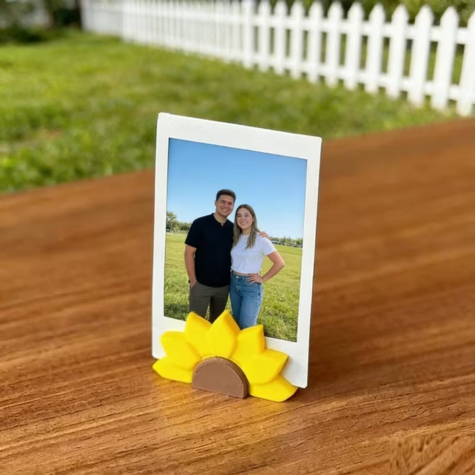 un porte-photo en forme de tournesol dans lequel est posé une photo d'un couple. L'ambiance est douce et calme. Idéal pour une touche décoration florale mignonne