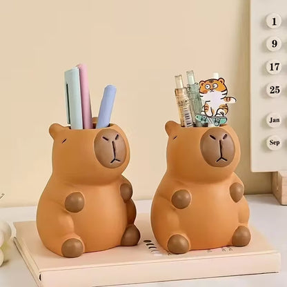 un pot à crayon en plastique en forme d'un adorable capybara. Il a une expression mignonne et toute calme. Elément de décoration de bureau amusante, originale et adorable.