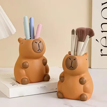 un pot à crayon en plastique en forme d'un adorable capybara. Il a une expression mignonne et toute calme. Elément de décoration de bureau amusante, originale et adorable.
