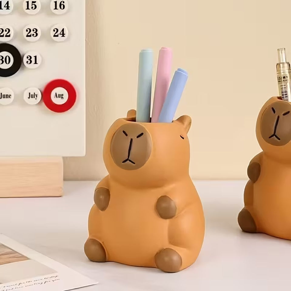 un pot à crayon en plastique en forme d'un adorable capybara. Il a une expression mignonne et toute calme. Elément de décoration de bureau amusante, originale et adorable.