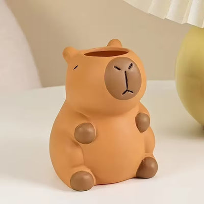 un pot à crayon en plastique en forme d'un adorable capybara. Il a une expression mignonne et toute calme. Elément de décoration de bureau amusante, originale et adorable.