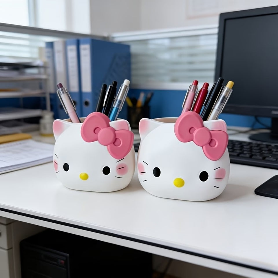 deux pots à crayons en forme d'Hello Kitty, posés sur un bureau blanc sur lequel se trouve aussi un ordinateur, des classeurs et divers fournitures de bureau. Style kawaii pour une ambiance mignonne et fun. 